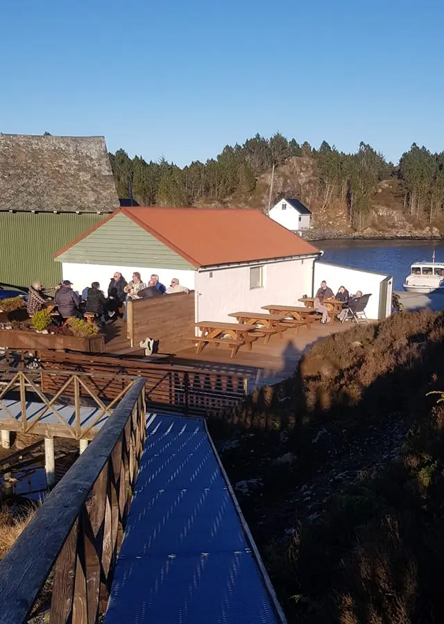 Terrasse med benker og bord ved sjøen